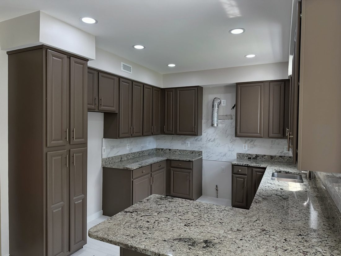 Refinished cabinets with marble-look backsplash